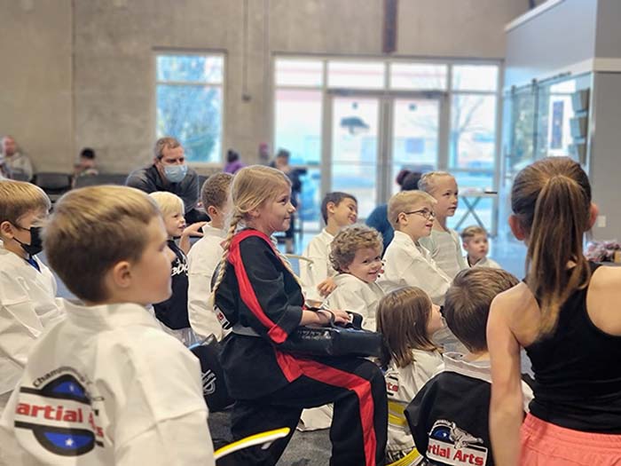 Taekwondo students gathered as a group listening to the instructor