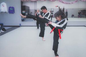 Two Championship Martial Arts Students performing a kick.